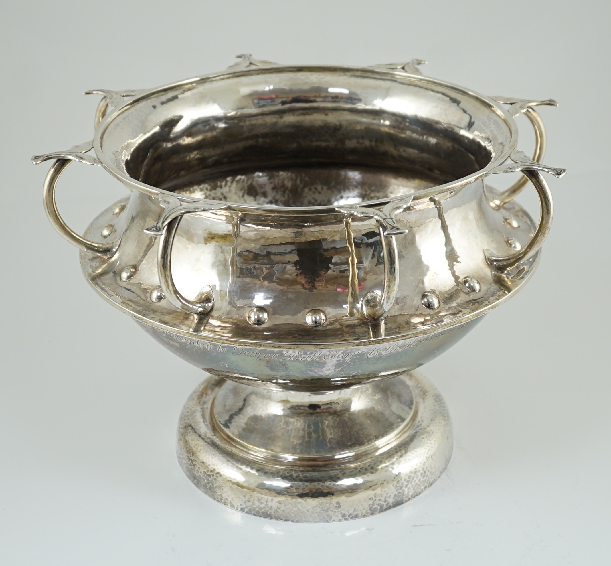 A George V Arts & Crafts planished silver octuple handled pedestal punch bowl, by Albert Edward Jones